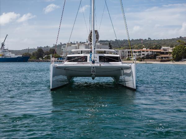 Slide: The Image of 2024 Seawind 1600 catamaran on calm water near a coastal town. - 5