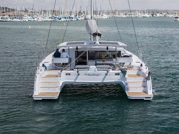 Slide: The Image of 2024 Seawind 1600 catamaran on water, rear view with marina background. - 6