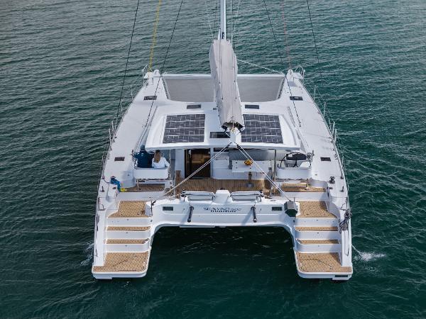 Slide: The Image of 2024 Seawind 1600 catamaran with solar panels on deck, sailing on calm waters. - 7