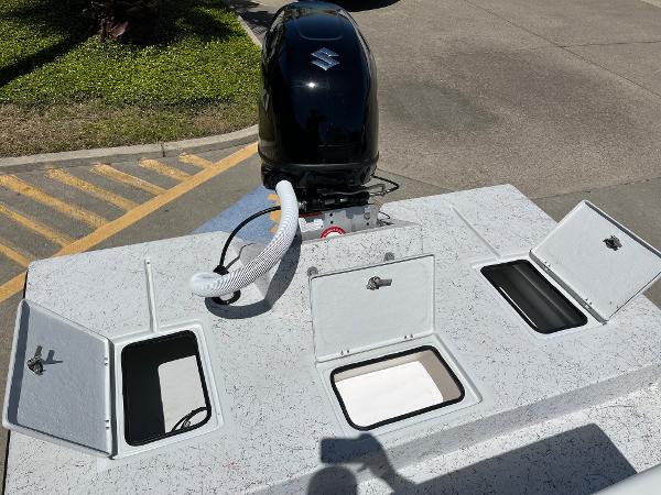 Slide: The Image of 2024 Shallow Stalker CAT-204 boat with open storage compartments and outboard motor. - 19