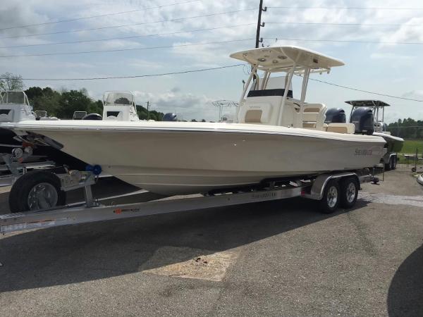 Slide: The Image of 2015 ShearWater 26 Carolina Flair boat on a trailer in a parking lot. - 1