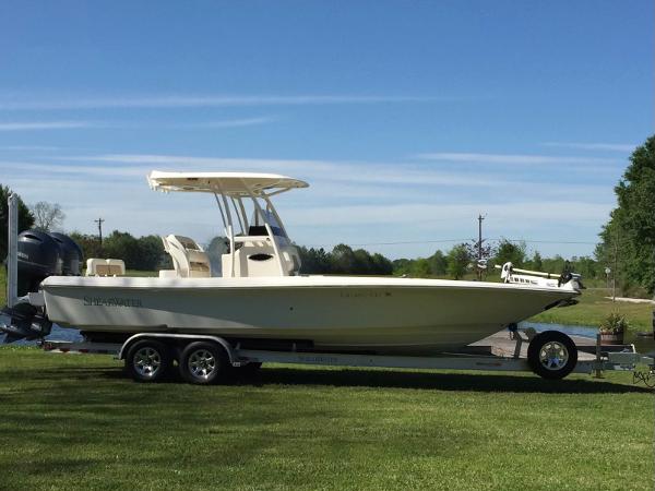Slide: The Image of 2015 ShearWater 26 Carolina Flair boat on a trailer in a grassy area. - 2