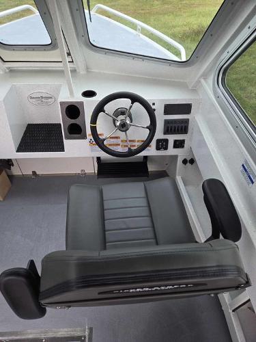 Slide: The Image of 2024 Silver Streak RENFREW boat cockpit with steering wheel and captain's chair. - 1