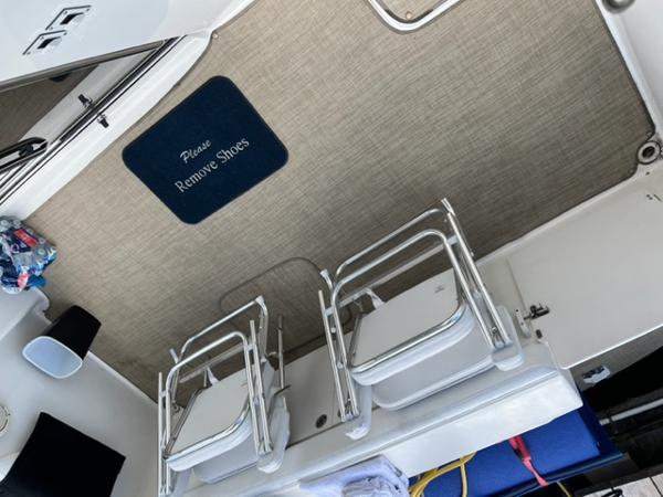 Slide: The Image of 2001 Silverton 330 Sport Bridge deck with chairs and Please Remove Shoes mat. - 17