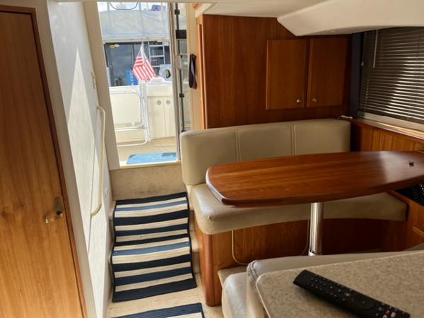 Slide: The Image of Interior of 2001 Silverton 330 Sport Bridge yacht with dining area and striped rug. - 19