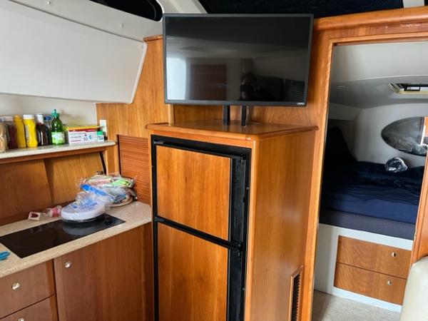 Slide: The Image of Interior of 2001 Silverton 330 Sport Bridge with kitchenette, fridge, and TV. - 22