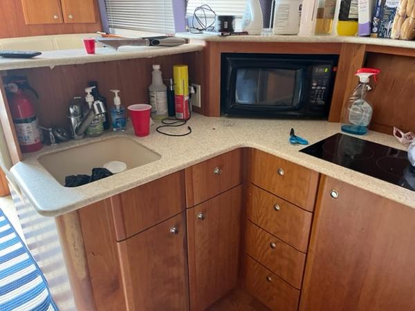 Slide: The Image of 2001 Silverton 330 Sport Bridge kitchen with sink, microwave, and storage cabinets. - 23