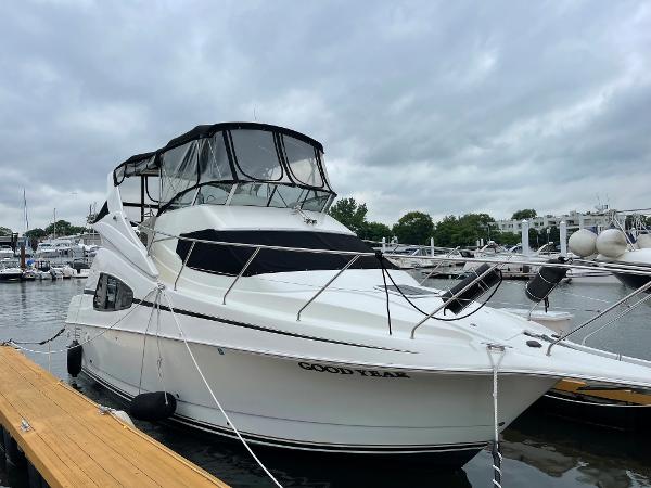 Slide: The Image of 2007 Silverton 330 Sport Bridge yacht docked at marina under cloudy sky. - 0