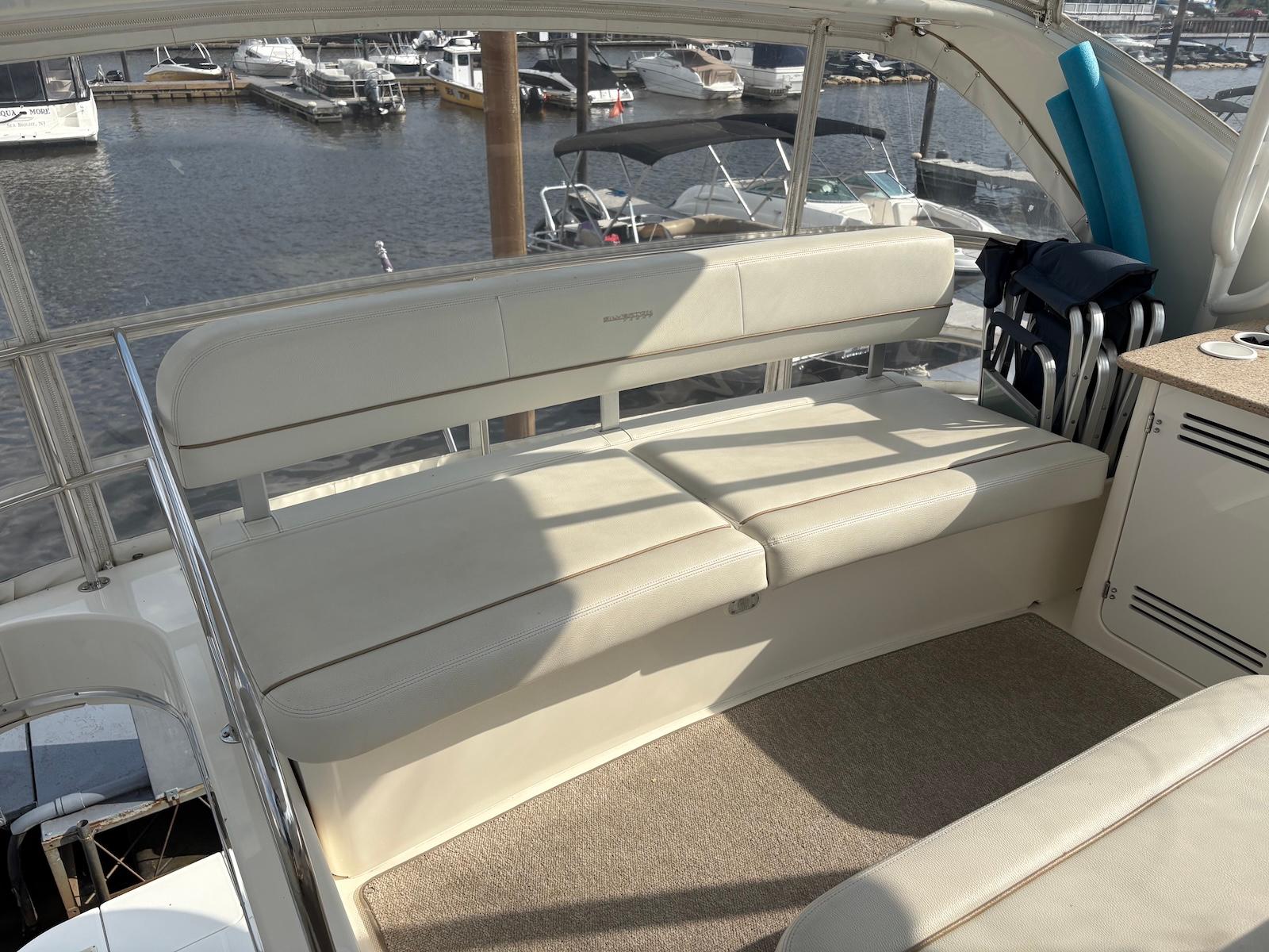 Slide: The Image of 2006 Silverton 38 Sport Bridge yacht interior with beige seating and marina view. - 11