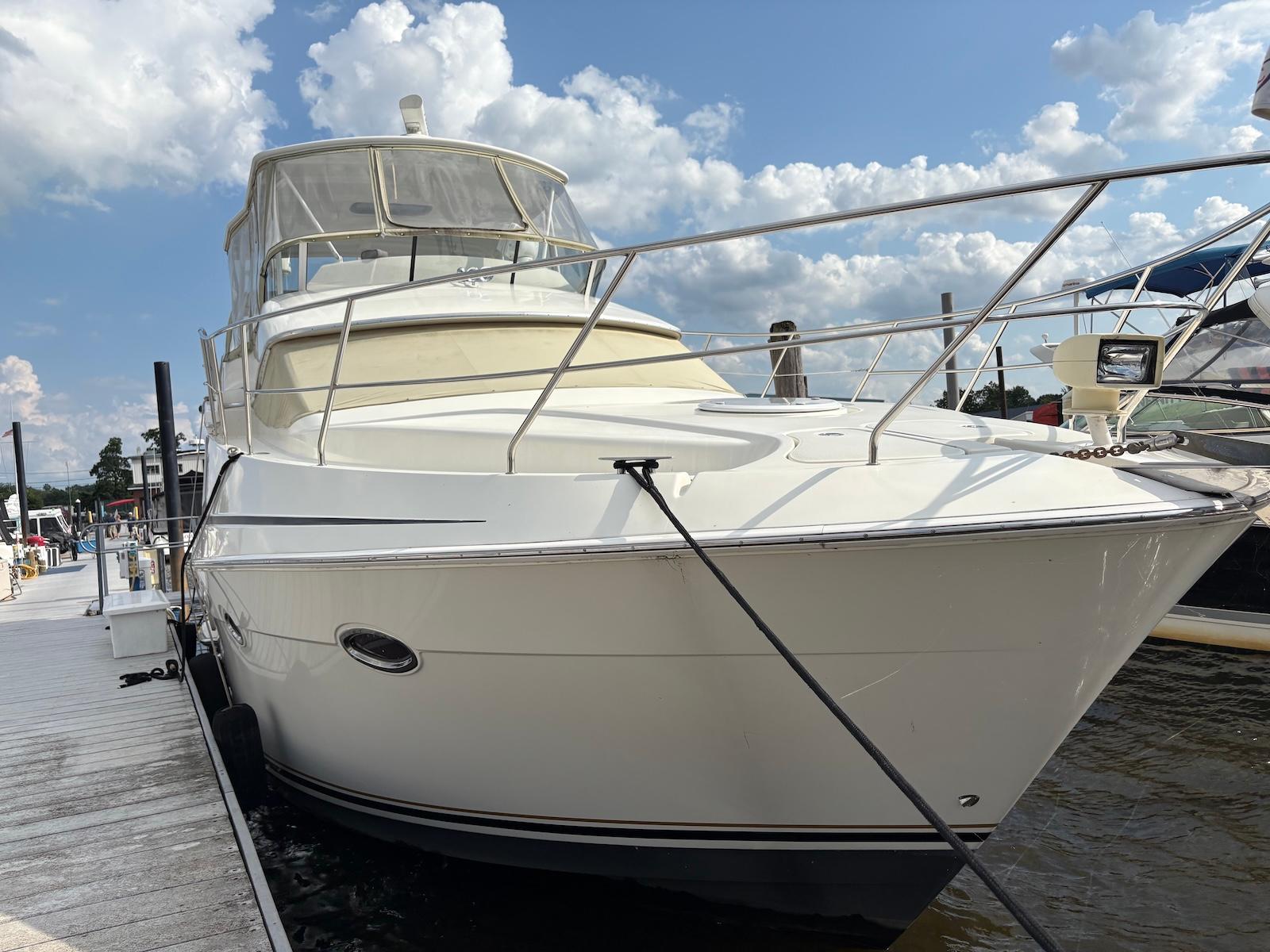Slide: The Image of 2006 Silverton 38 Sport Bridge yacht docked under a partly cloudy sky. - 12