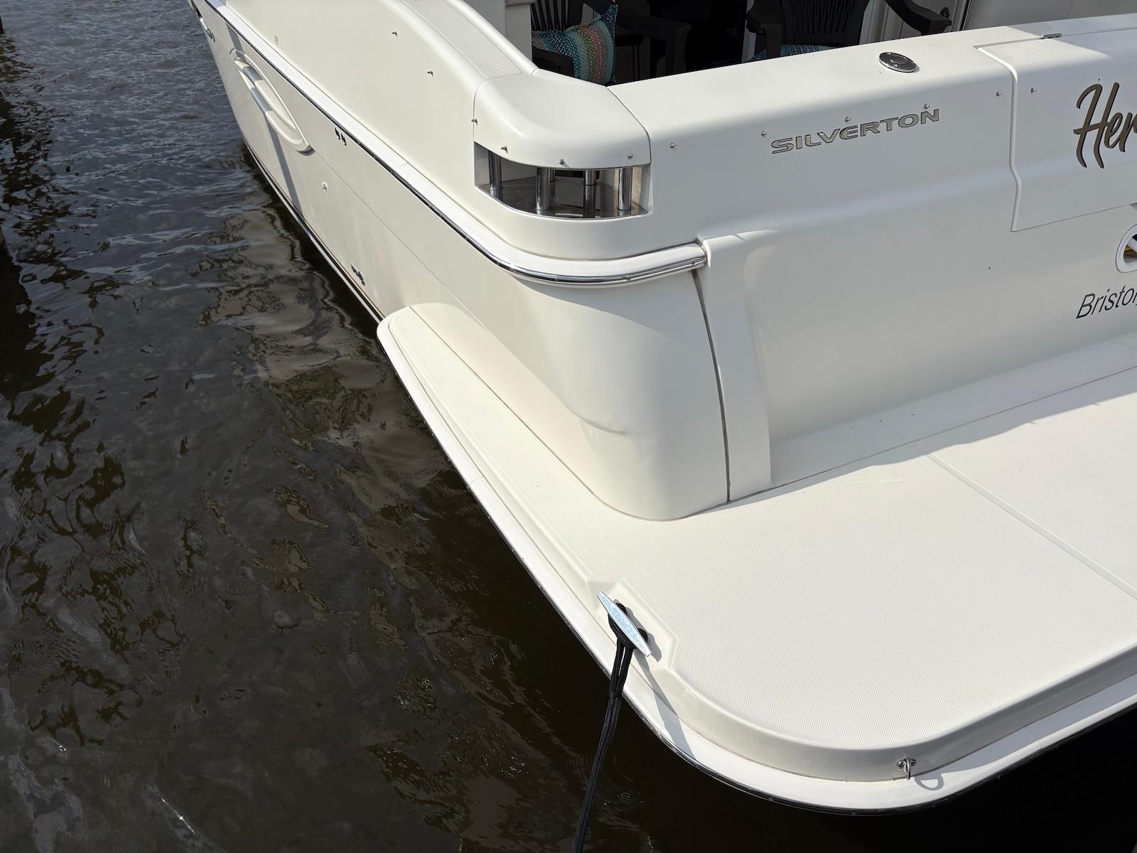 Slide: The Image of 2006 Silverton 38 Sport Bridge yacht docked on calm water. - 14