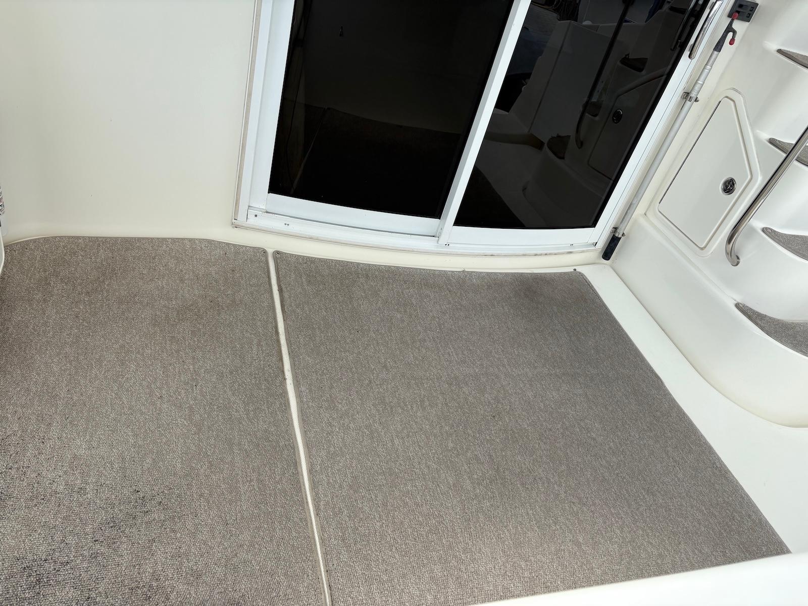 Slide: The Image of Interior view of a 2006 Silverton 38 Sport Bridge with carpeted flooring and sliding door. - 16