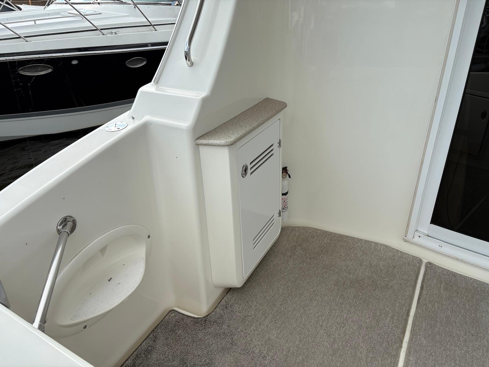 Slide: The Image of 2006 Silverton 38 Sport Bridge interior with storage cabinet and carpeted flooring. - 17