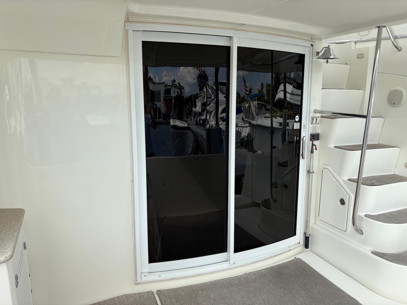 Slide: The Image of 2006 Silverton 38 Sport Bridge yacht interior with sliding glass doors and staircase. - 18