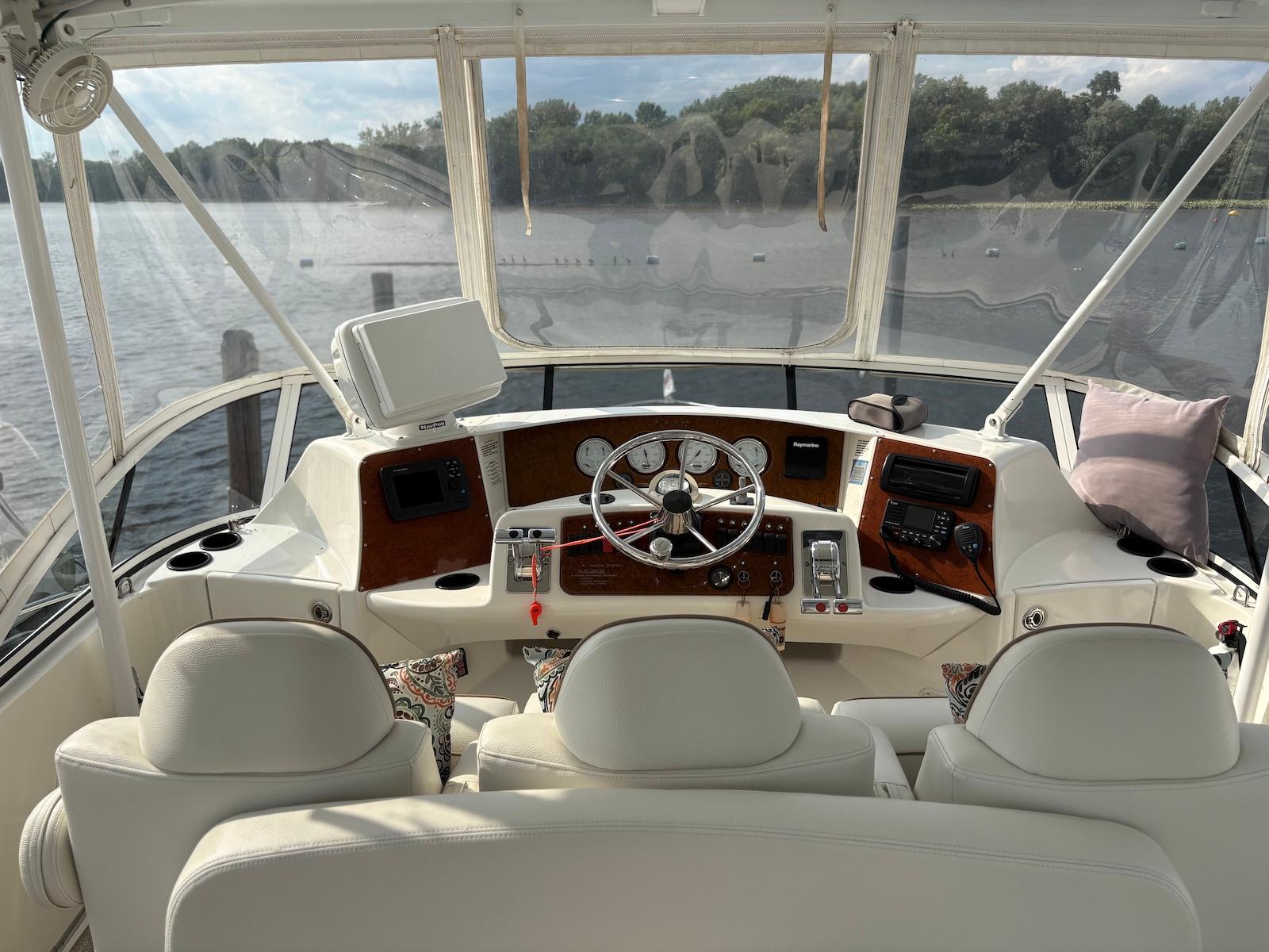 Slide: The Image of 2006 Silverton 38 Sport Bridge helm with steering wheel, gauges, and navigation equipment. - 2