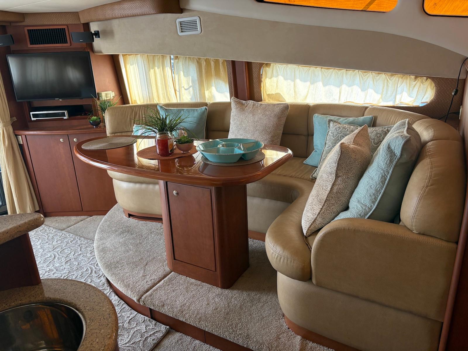 Slide: The Image of 2006 Silverton 38 Sport Bridge interior with cozy seating, pillows, and a small table. - 20