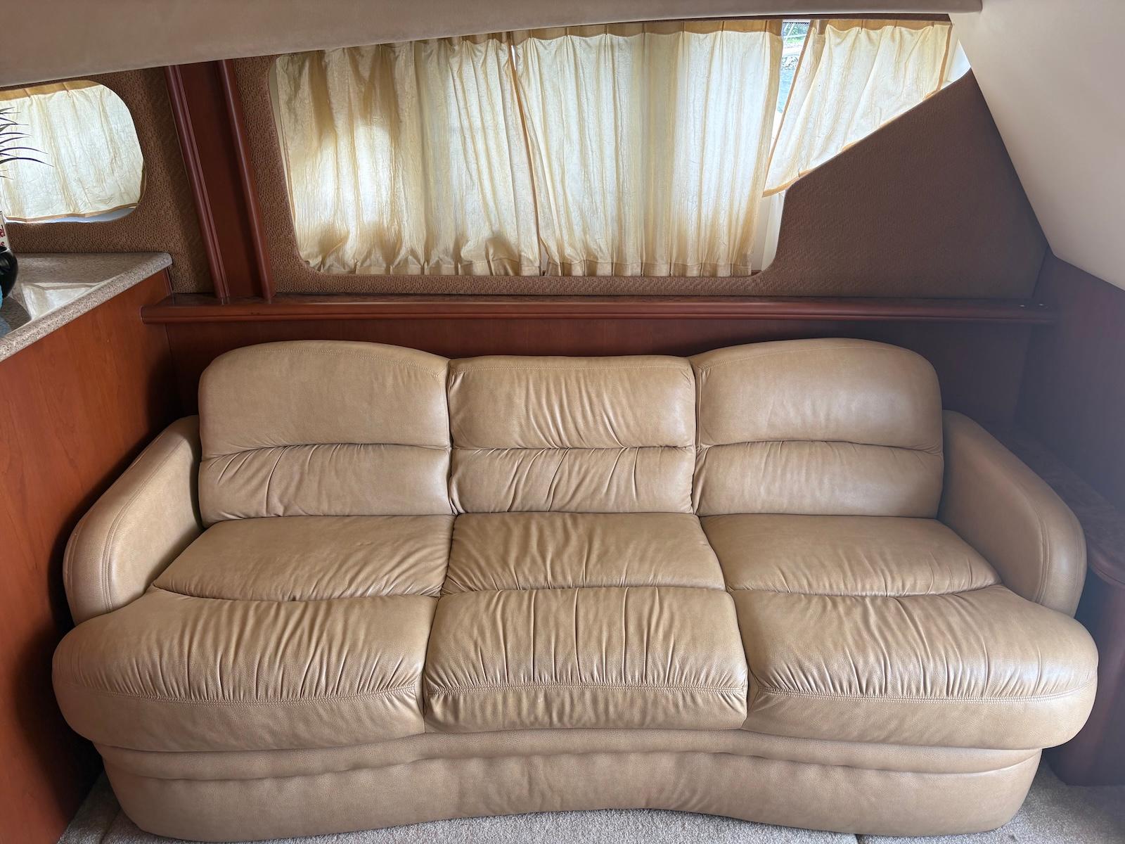 Slide: The Image of Beige leather sofa inside 2006 Silverton 38 Sport Bridge yacht, with curtains and wooden accents. - 21