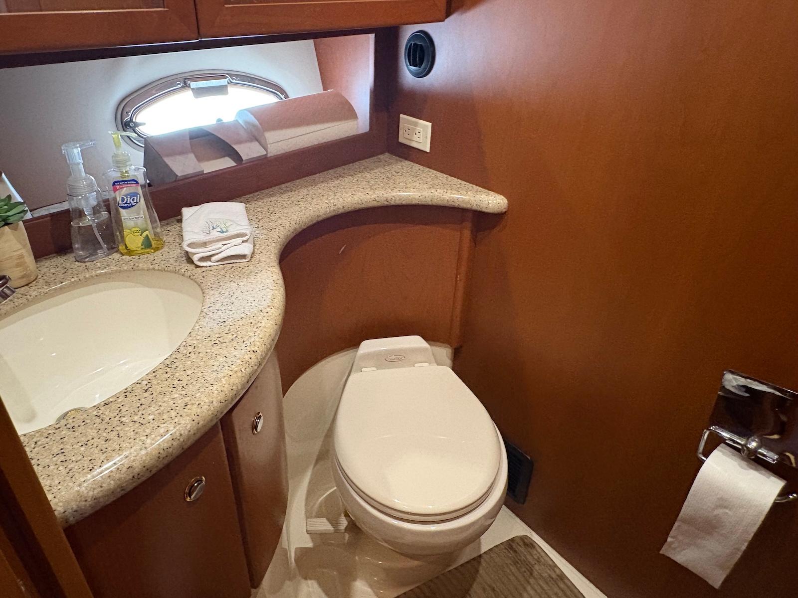 Slide: The Image of Bathroom interior of 2006 Silverton 38 Sport Bridge yacht, featuring sink and toilet. - 28