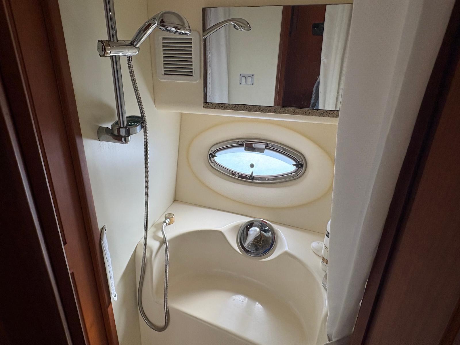 Slide: The Image of Bathroom interior of a 2006 Silverton 38 Sport Bridge yacht with shower and porthole. - 29