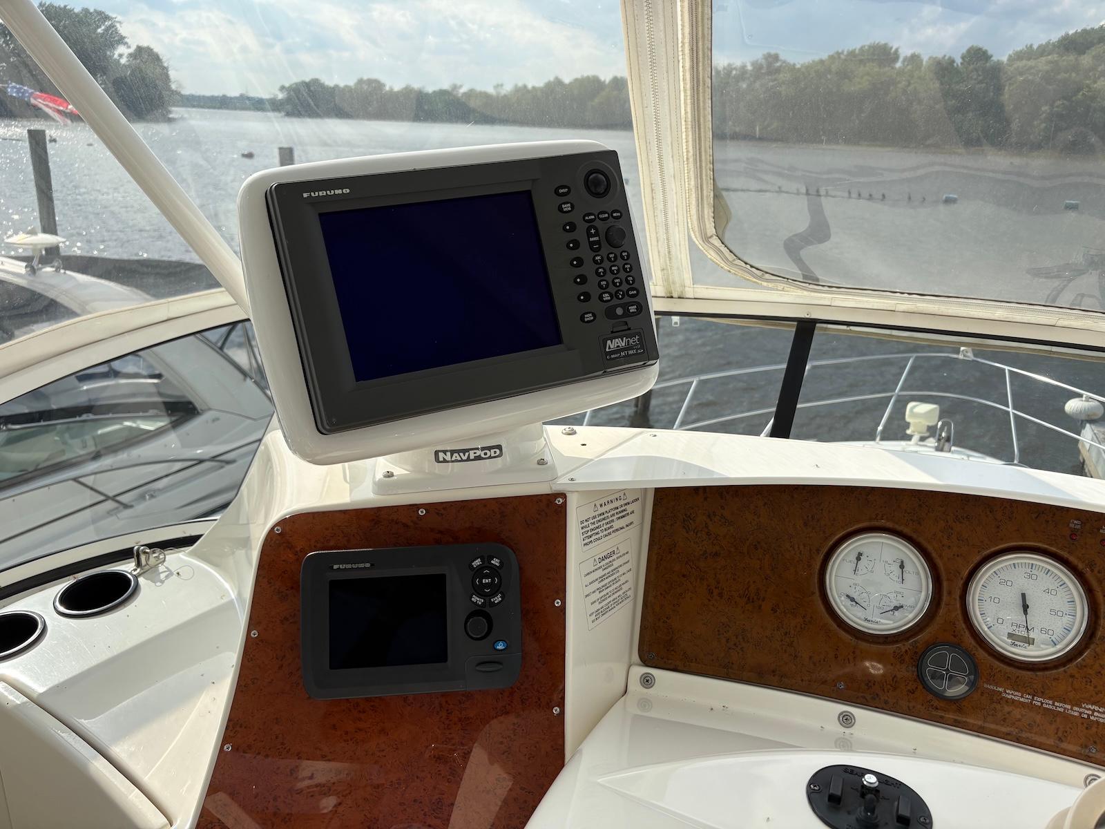 Slide: The Image of 2006 Silverton 38 Sport Bridge helm with navigation equipment and gauges on a river. - 6