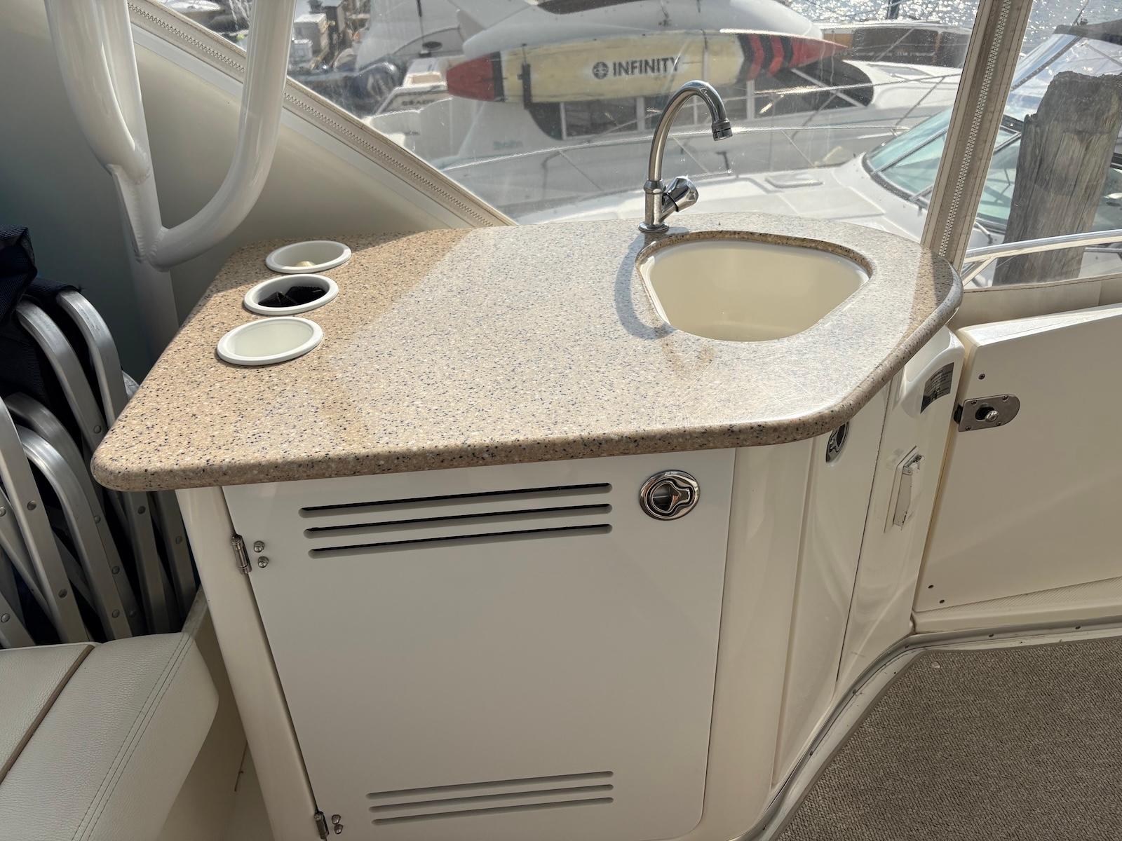Slide: The Image of 2006 Silverton 38 Sport Bridge boat with a compact kitchenette and sink. - 9