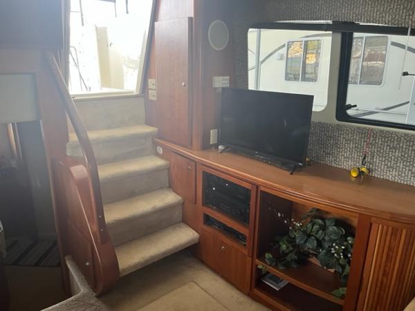 Slide: The Image of Interior of 2002 Silverton 39 Motor Yacht with TV, stairs, and wooden cabinetry. - 20