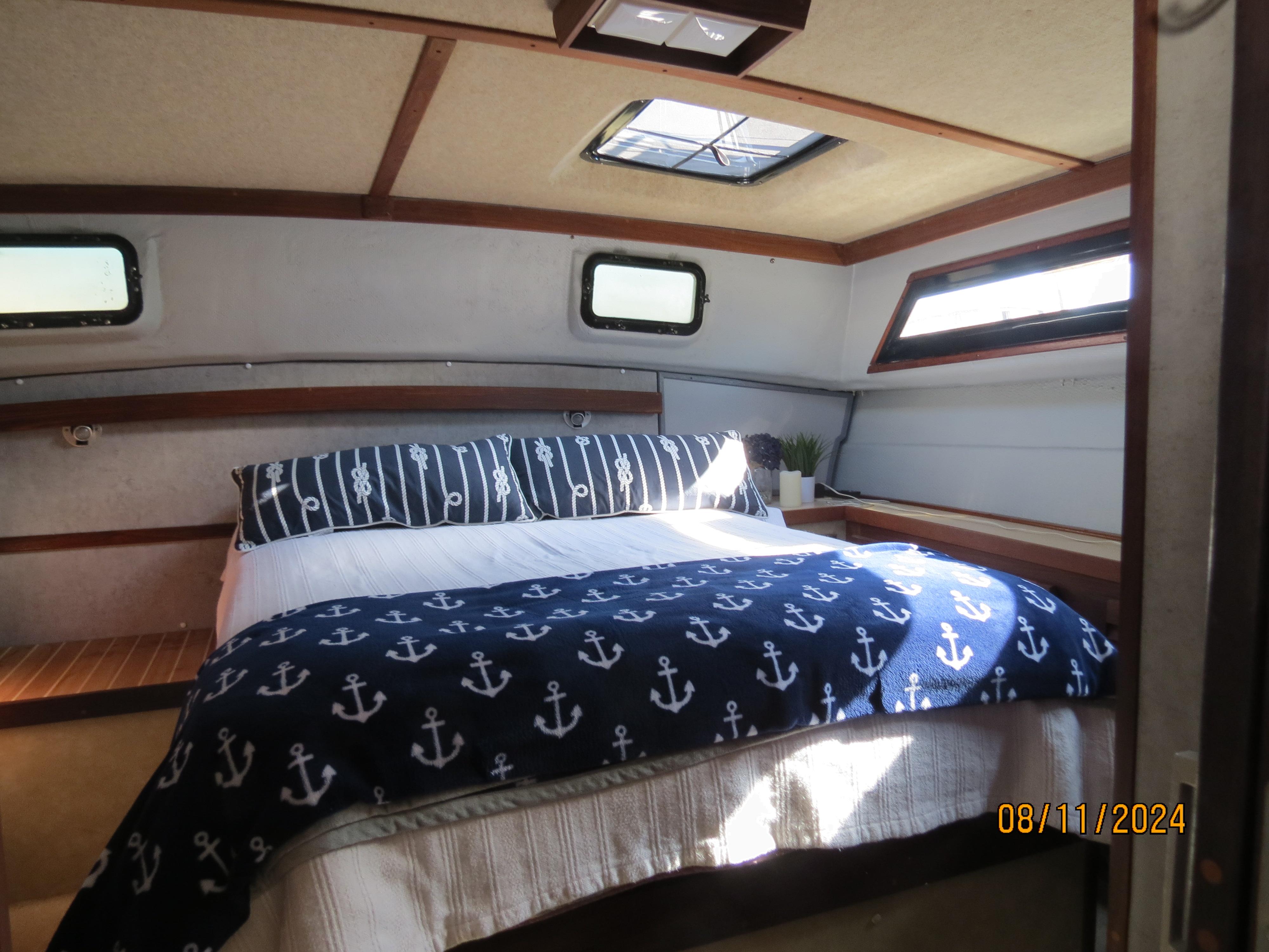 Slide: The Image of Cozy cabin interior of 1983 Silverton 40 Aft Cabin with nautical-themed bedding. - 12