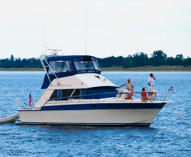 Slide: The Image of 1988 Silverton 40 Convertible yacht on calm water with people enjoying the view. - 0