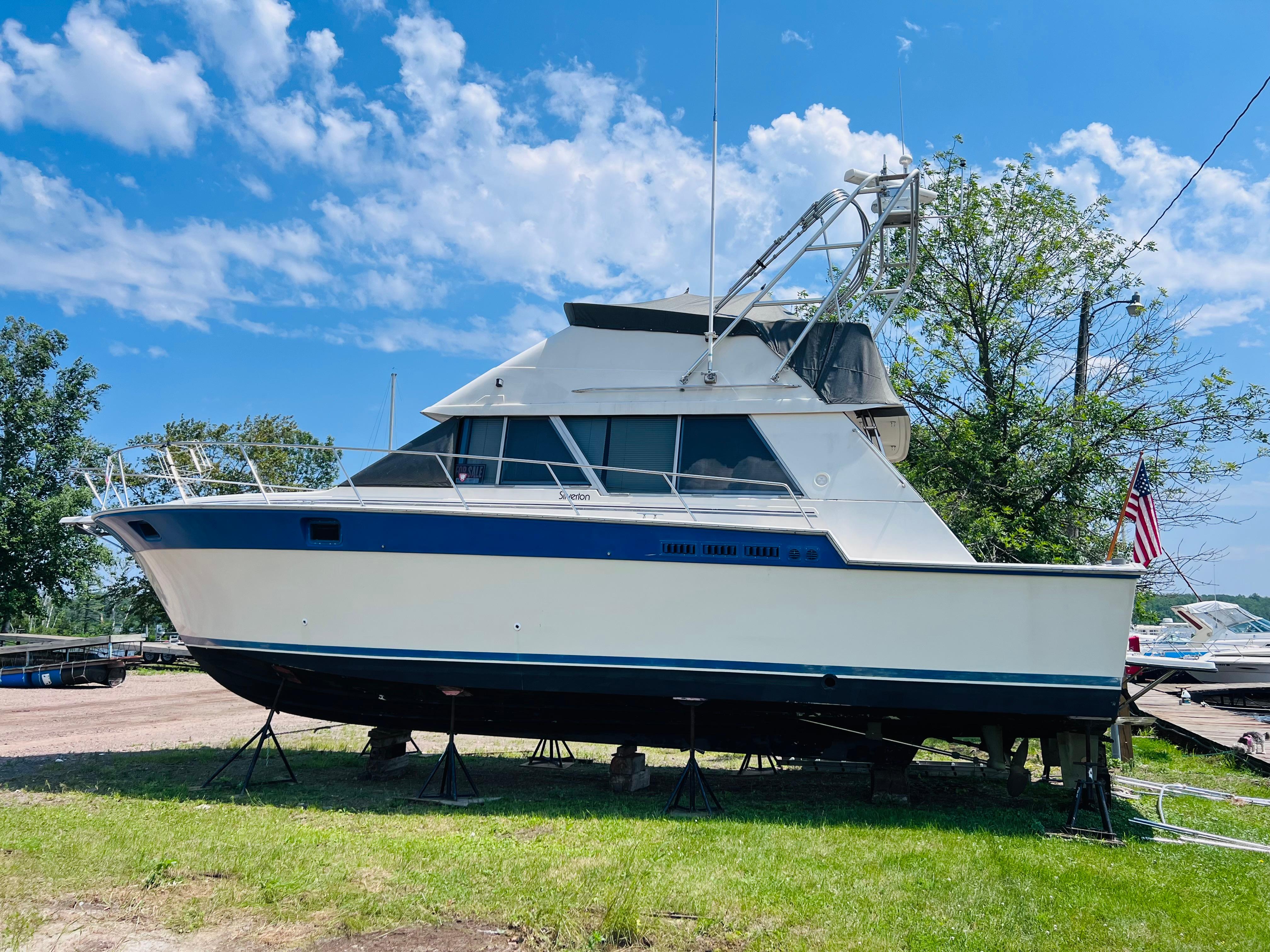 Slide: The Image of 1988 Silverton 40 Convertible boat on stands, clear sky background. - 2