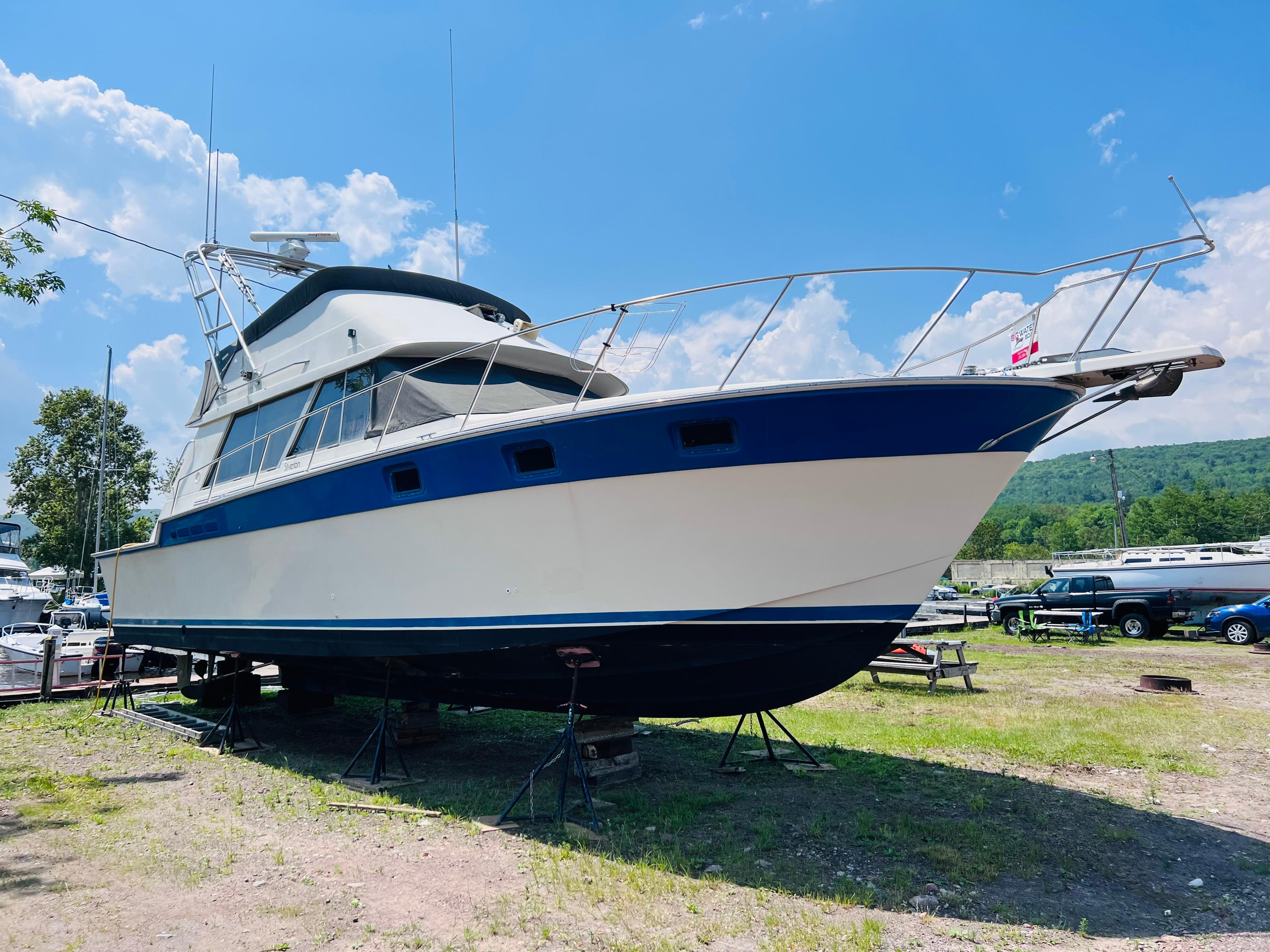 Slide: The Image of 1988 Silverton 40 Convertible boat on land under a clear blue sky. - 5