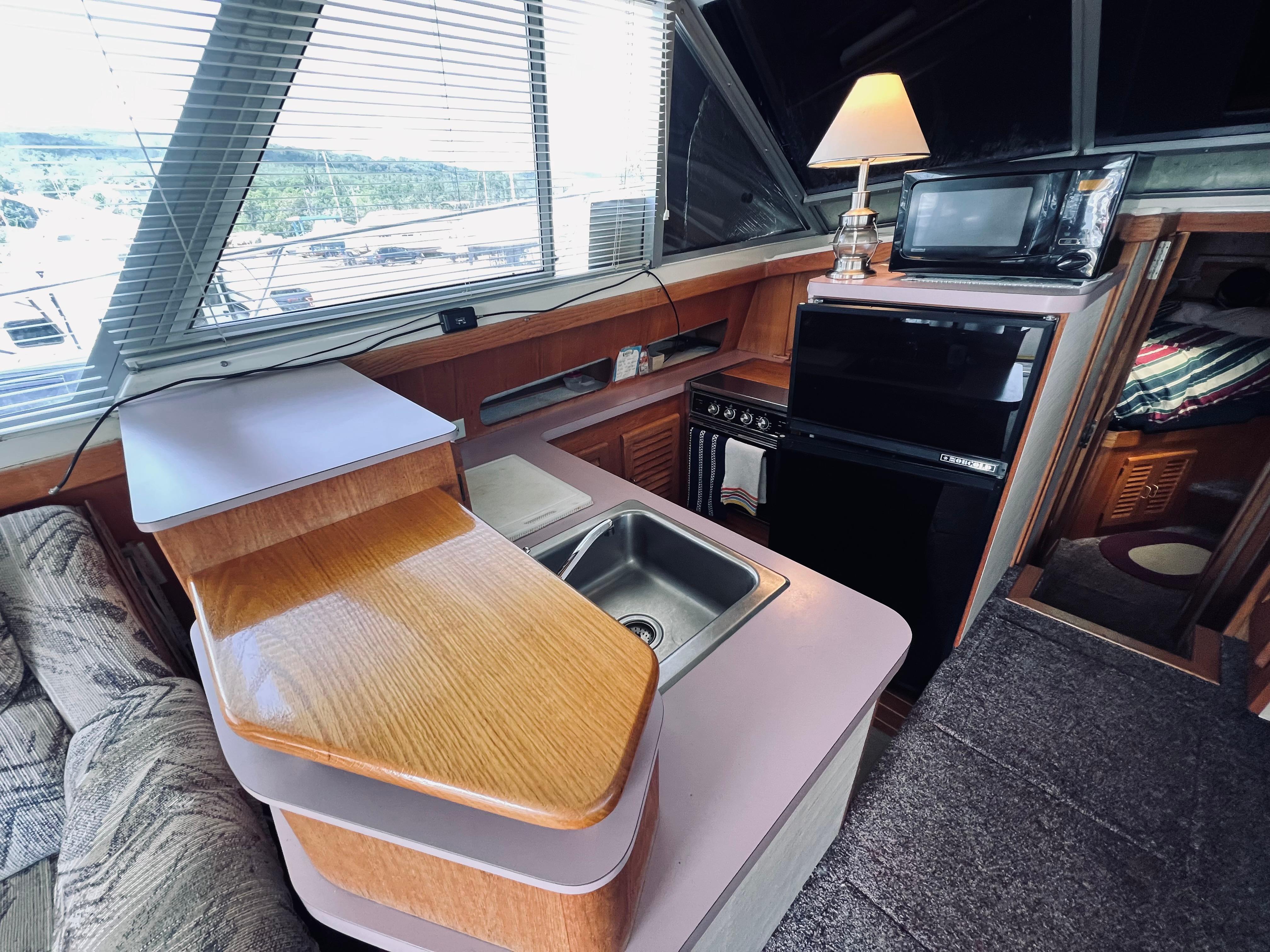Slide: The Image of Interior of 1988 Silverton 40 Convertible yacht with kitchen and cozy seating area. - 7