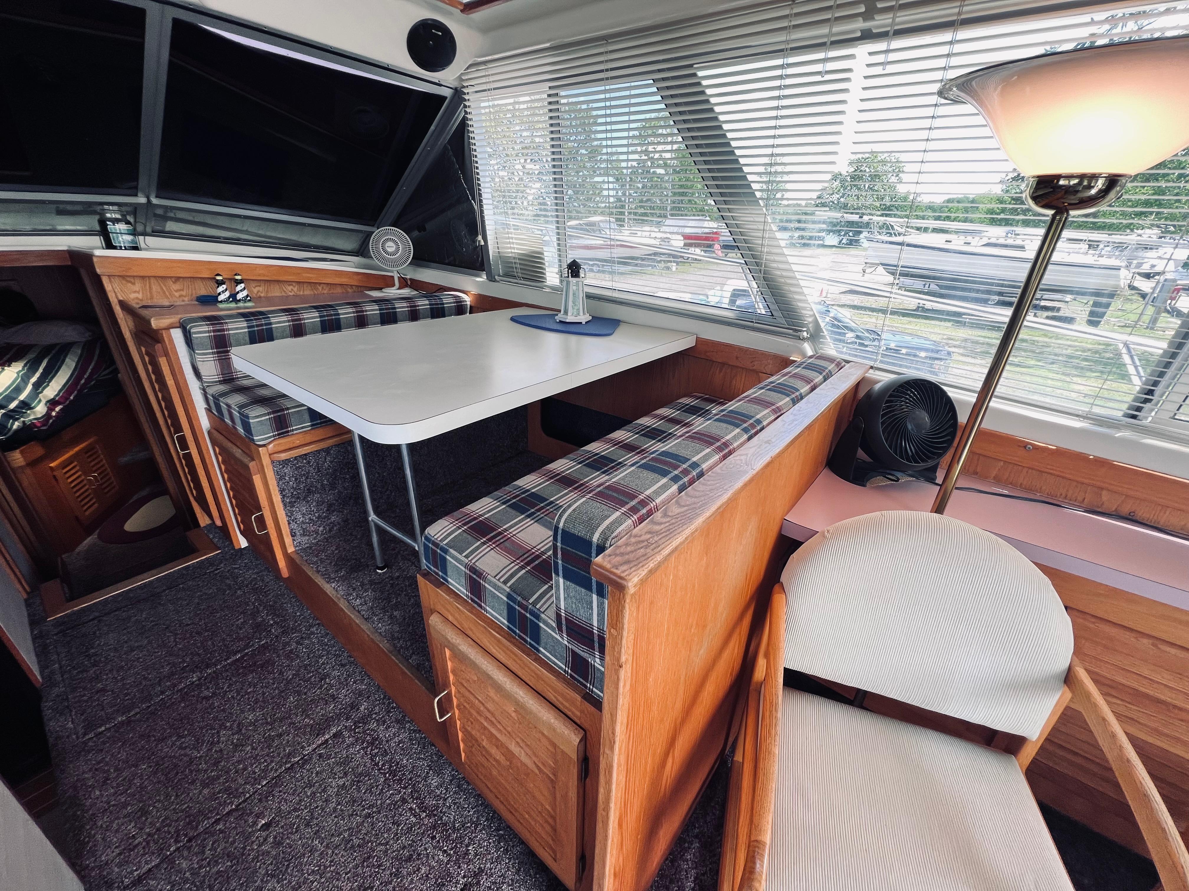 Slide: The Image of Interior of 1988 Silverton 40 Convertible yacht with dining area and plaid seating. - 8