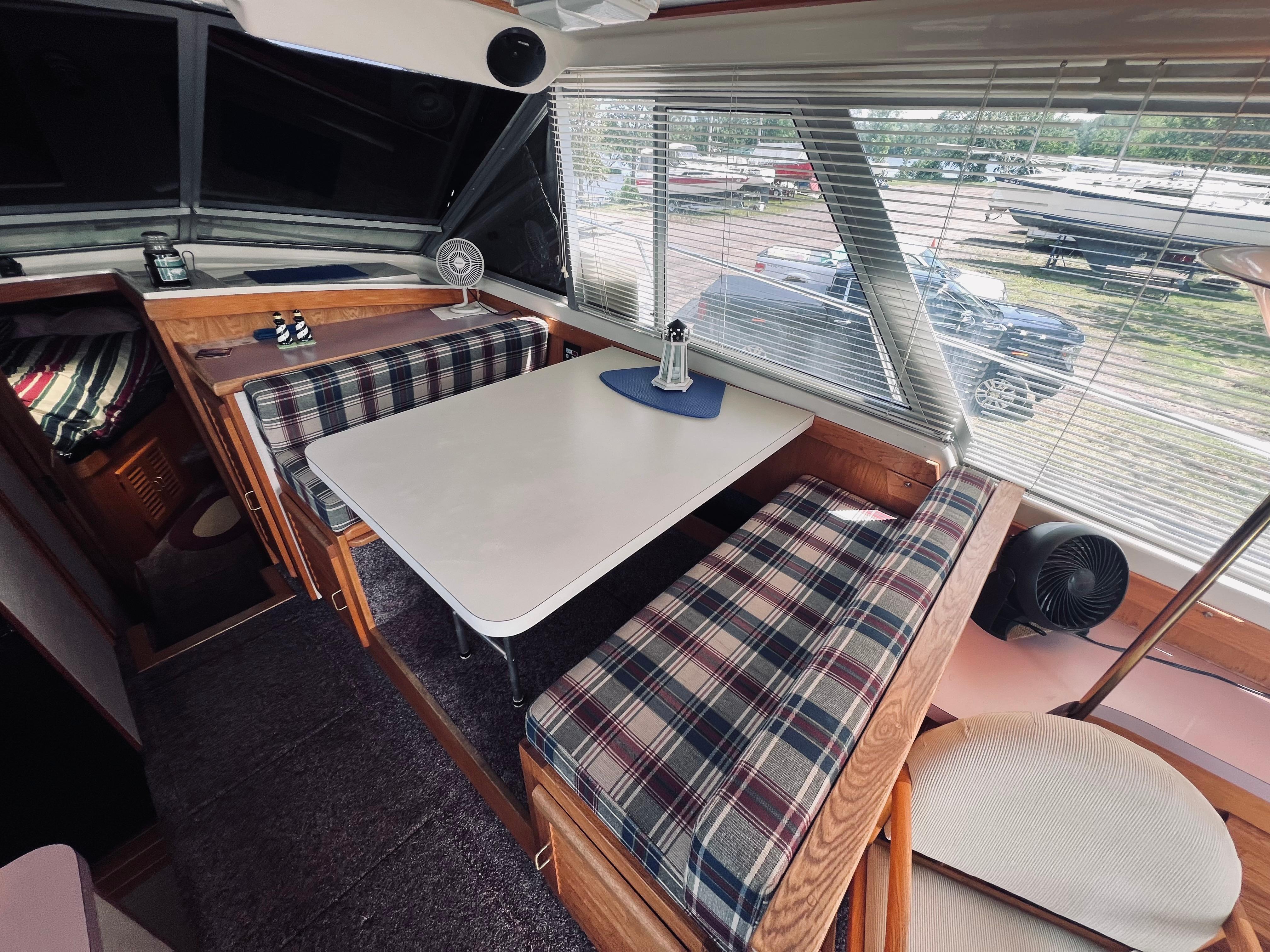 Slide: The Image of Interior of 1988 Silverton 40 Convertible with plaid seating and dining table. - 9