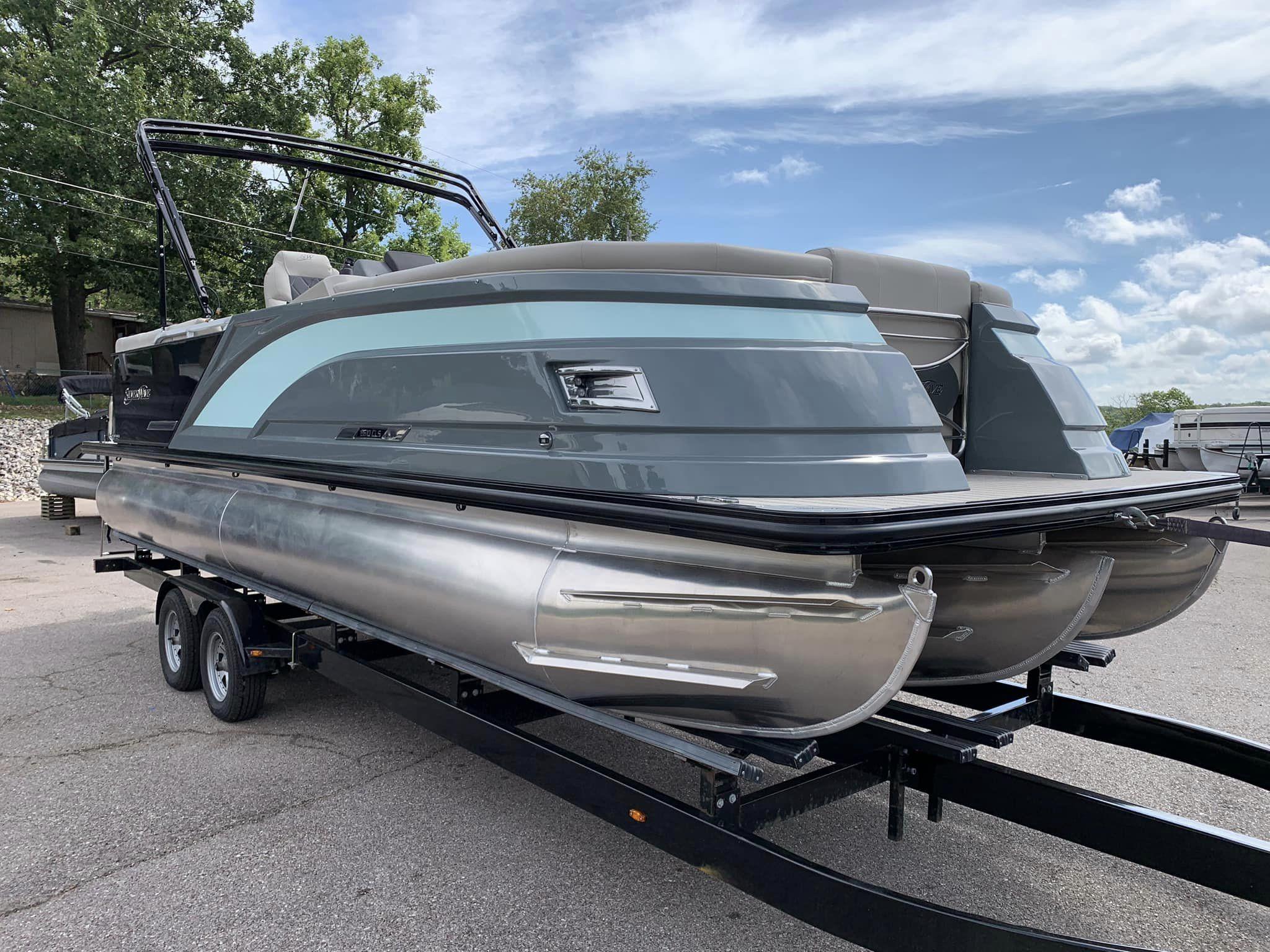 Slide: The Image of 2024 Silver Wave 2610 SW5 CLS pontoon boat on trailer, parked outdoors. - 2