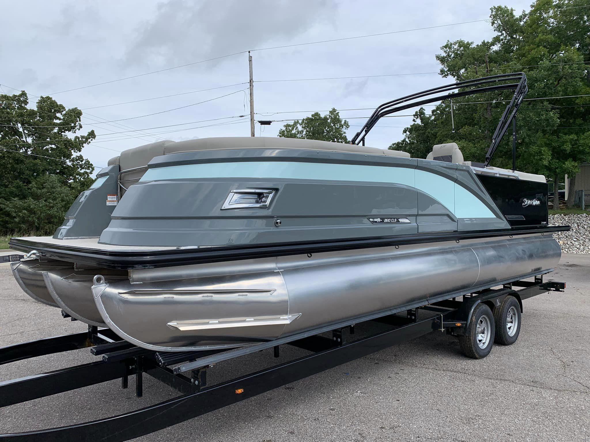 Slide: The Image of 2024 Silver Wave 2610 SW5 CLS pontoon boat on trailer, sleek design, parked outdoors. - 6