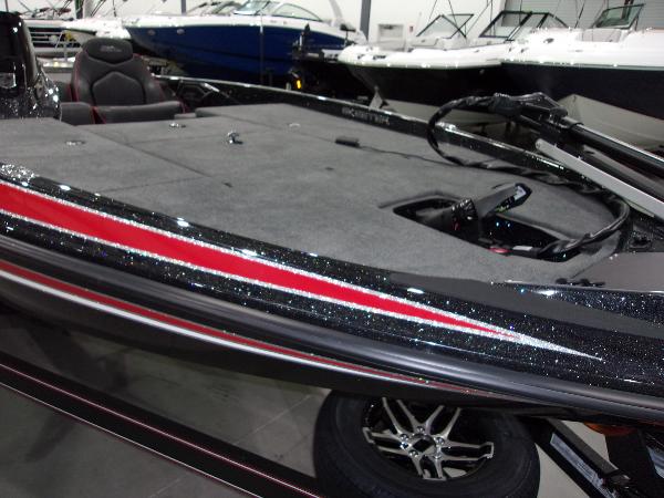 Slide: The Image of 2024 Skeeter ZX-150 bass boat with red and black detailing in showroom. - 4