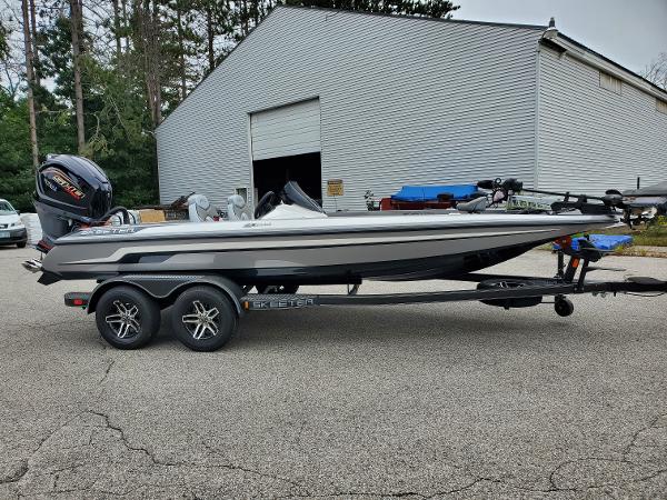 Slide: The Image of 2023 Skeeter ZX200 bass boat on a trailer in front of a garage. - 2