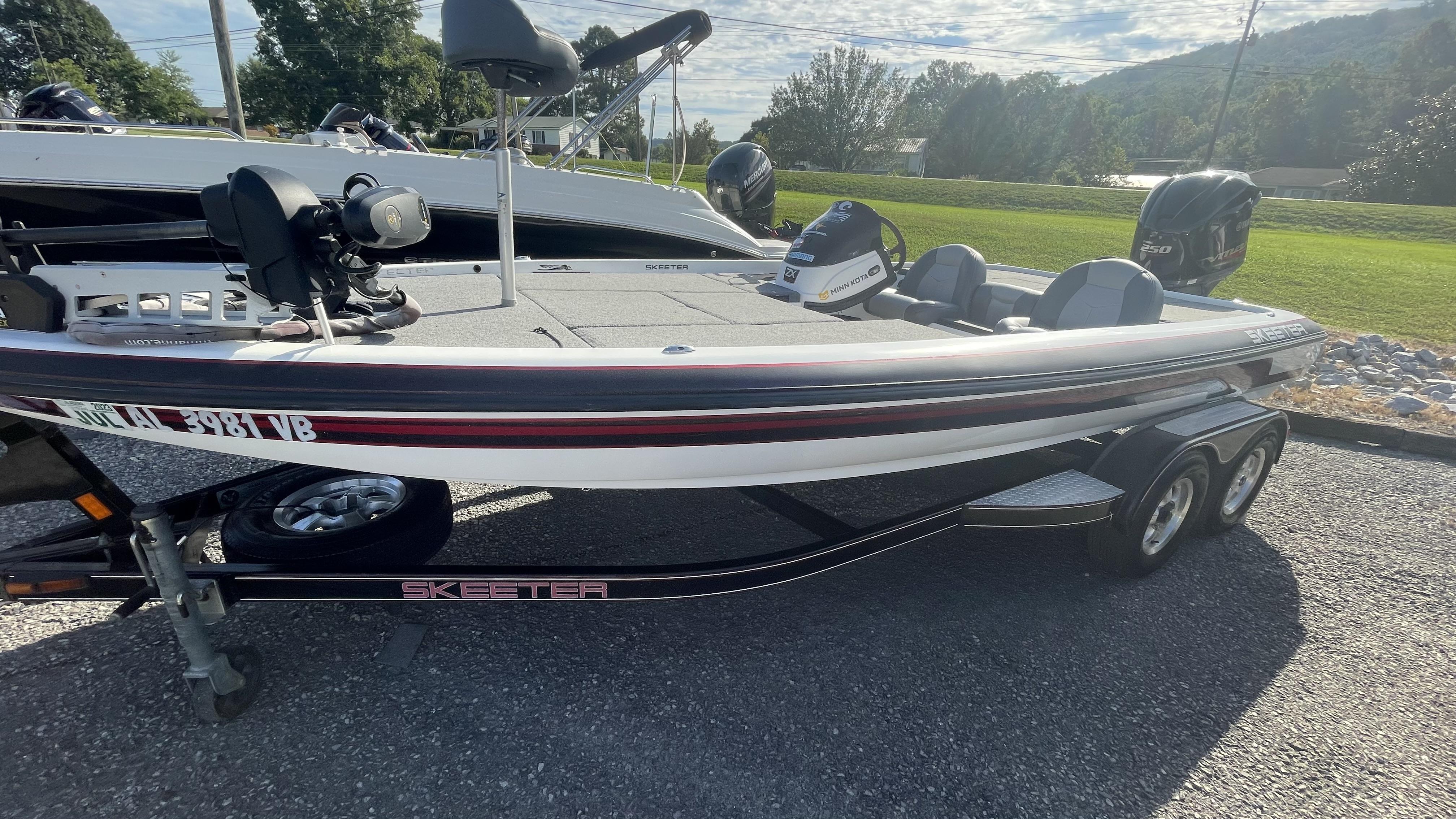 Slide: The Image of 2011 Skeeter ZX225 bass boat on a trailer, parked outdoors. - 1