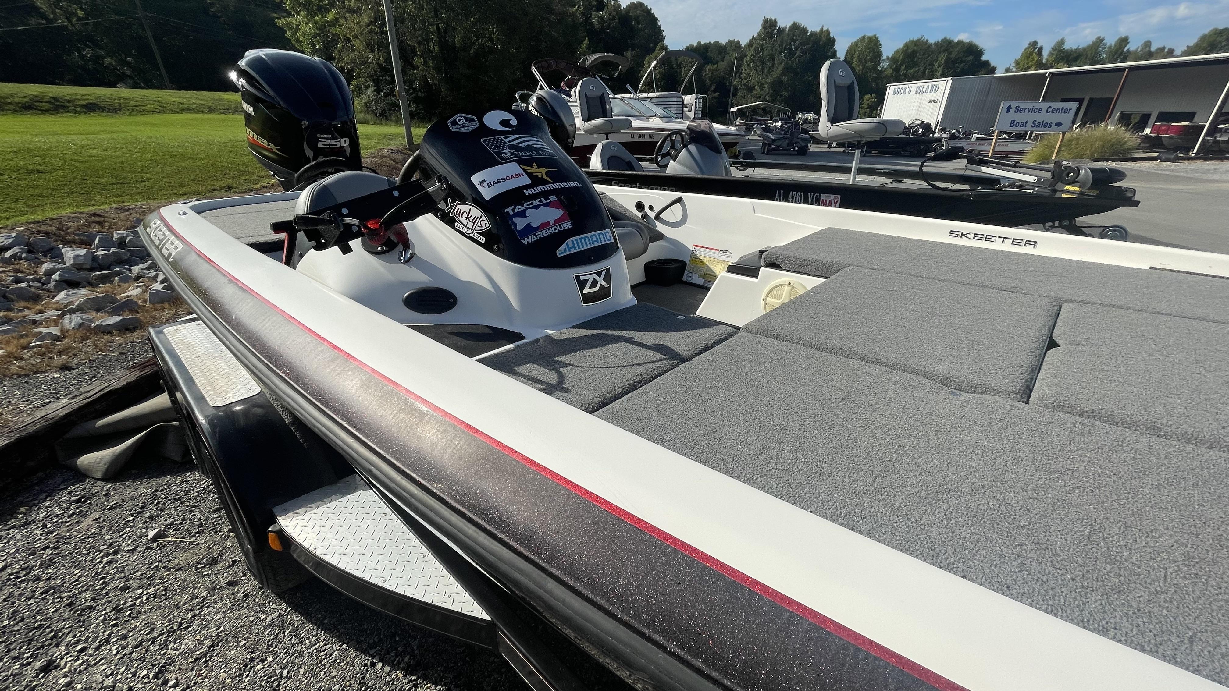 Slide: The Image of 2011 Skeeter ZX225 bass boat with Yamaha 250 engine, parked at a boat sales center. - 15