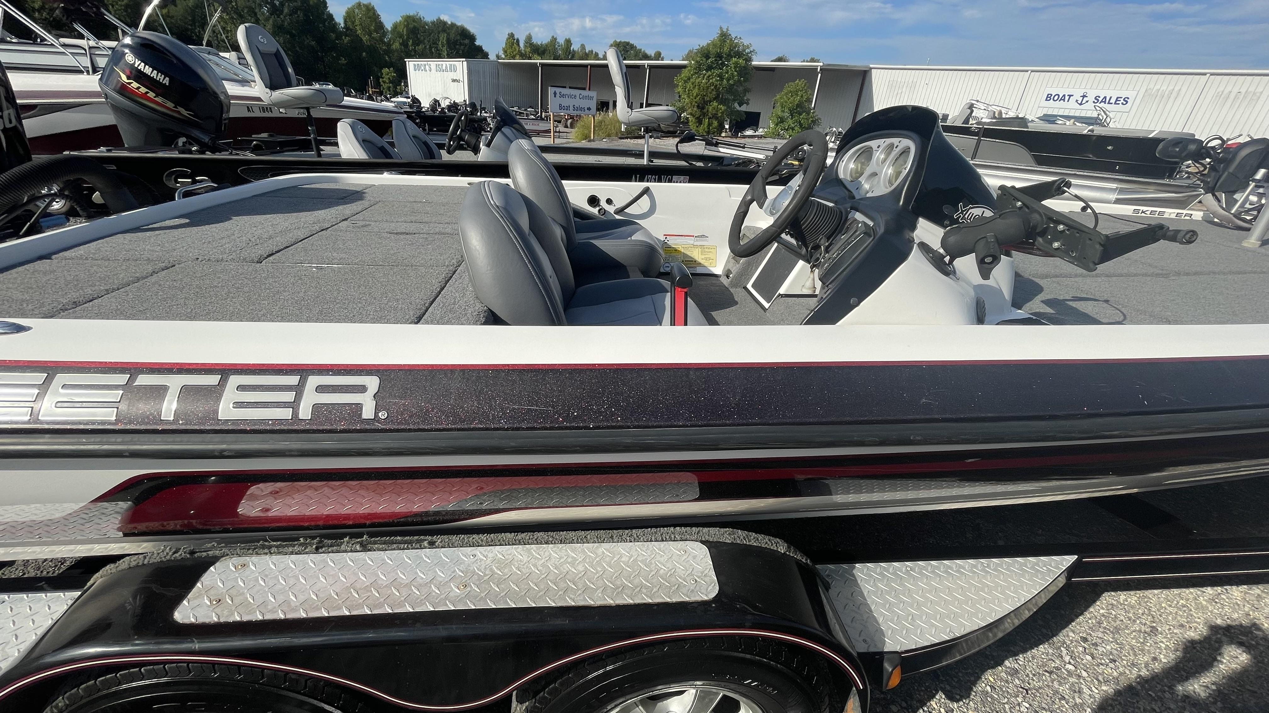 Slide: The Image of 2011 Skeeter ZX225 bass boat with Yamaha outboard motor at a boat sales lot. - 2