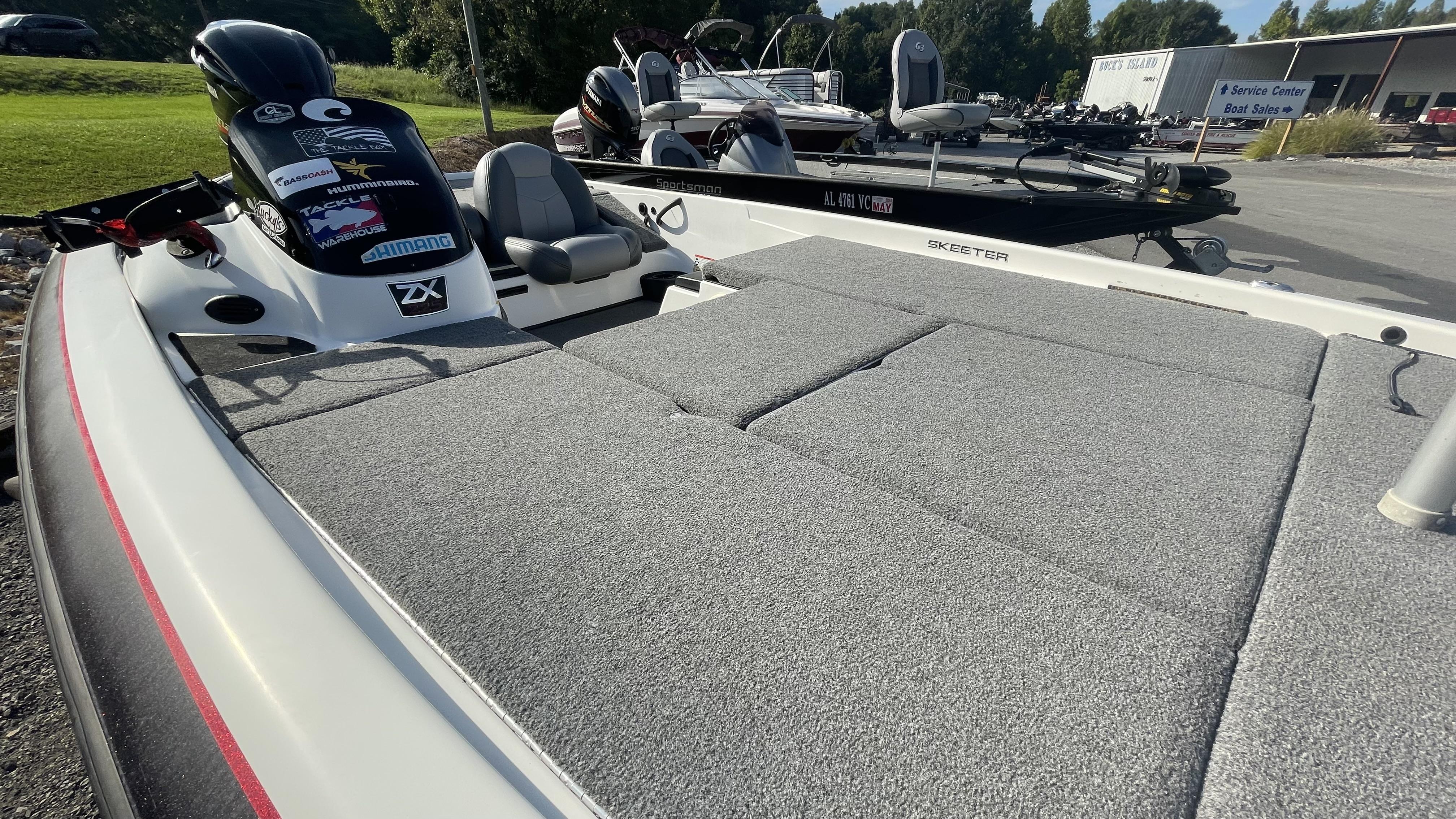 Slide: The Image of 2011 Skeeter ZX225 bass boat with gray carpeted deck and motor. - 20