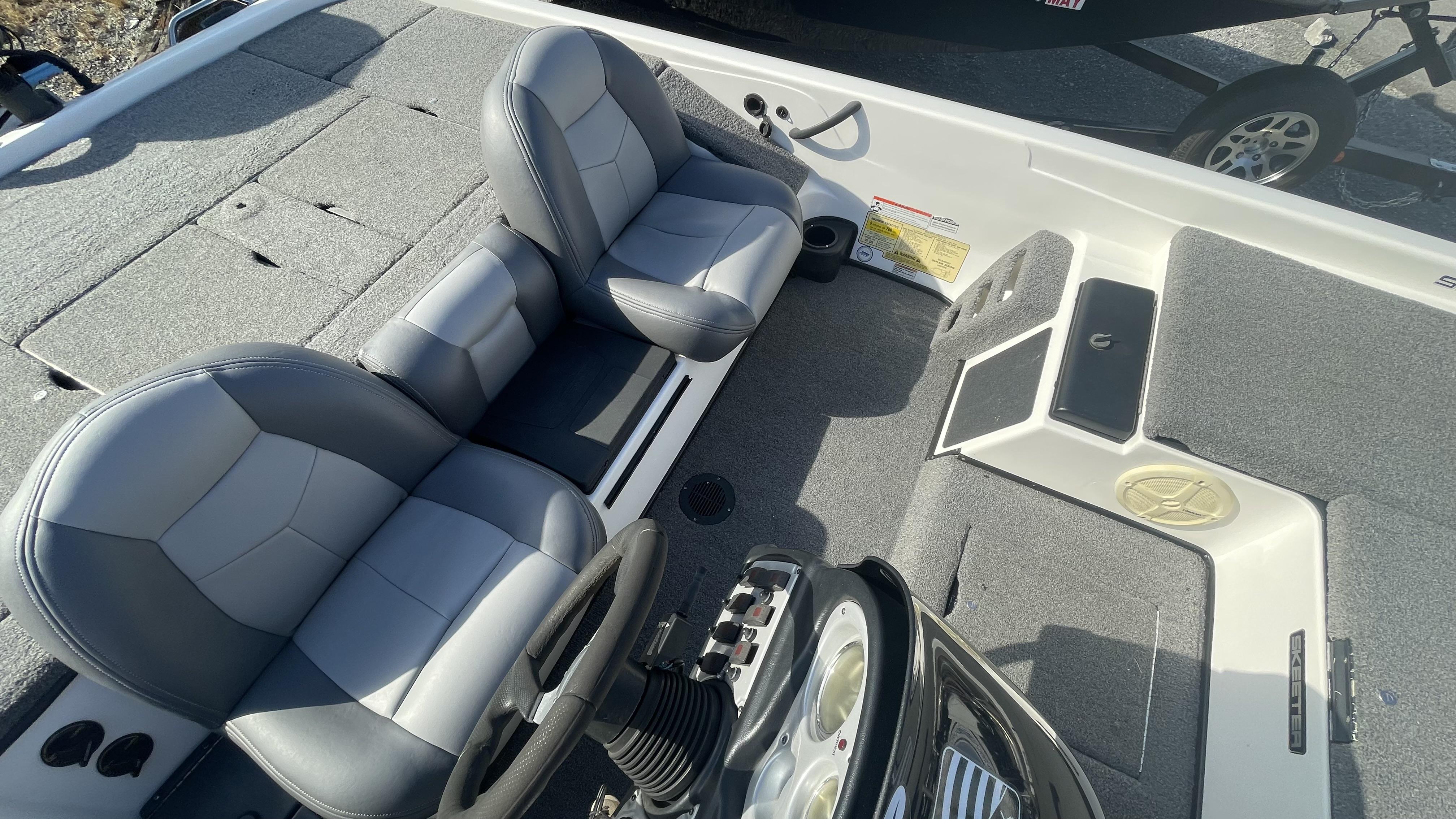 Slide: The Image of 2011 Skeeter ZX225 boat interior with gray seats and carpeted flooring. - 22