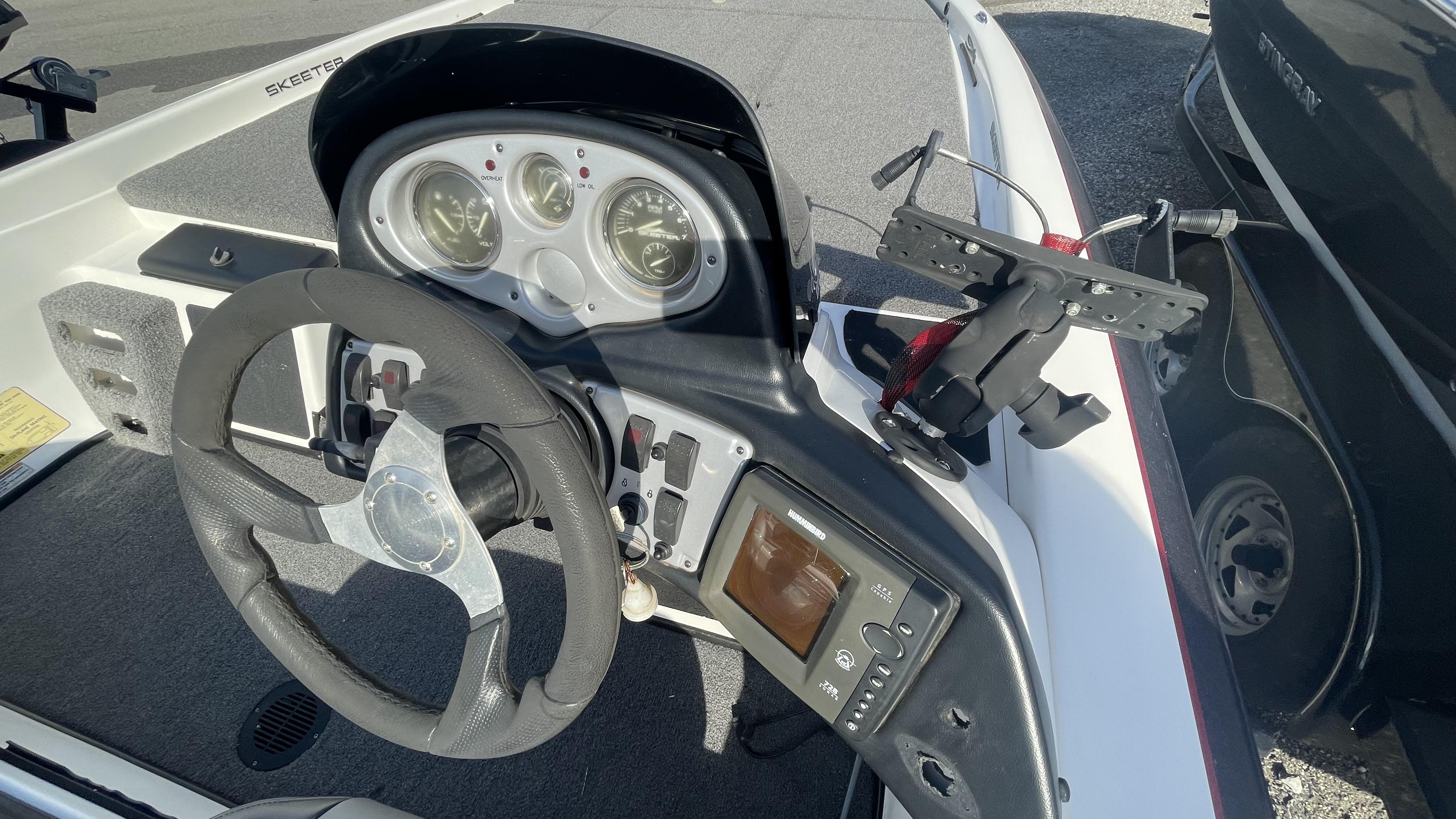 Slide: The Image of 2011 Skeeter ZX225 boat dashboard with steering wheel, gauges, and electronic display. - 23