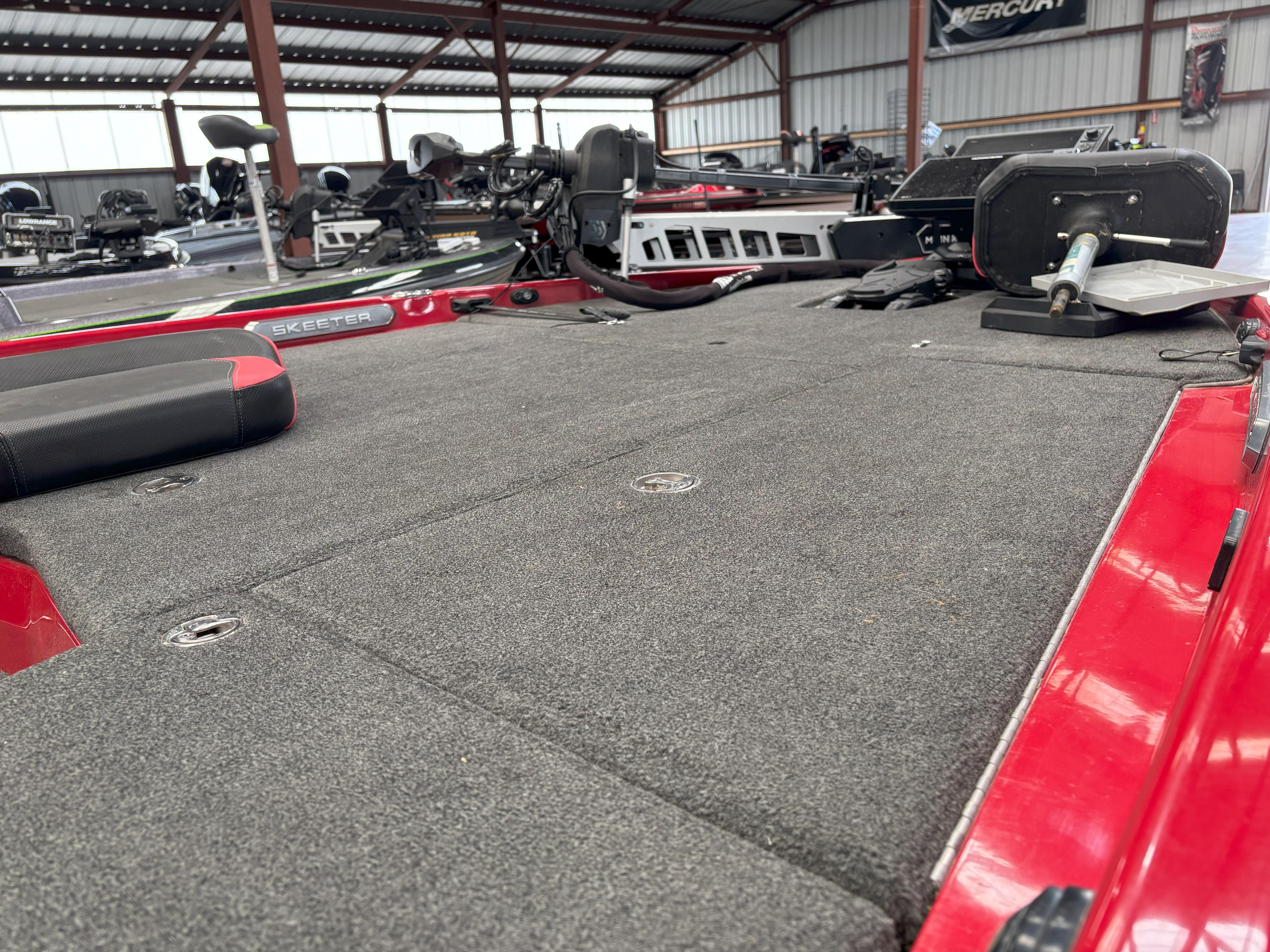 Slide: The Image of 2020 Skeeter FXR20 Apex boat interior with red accents in a storage facility. - 12