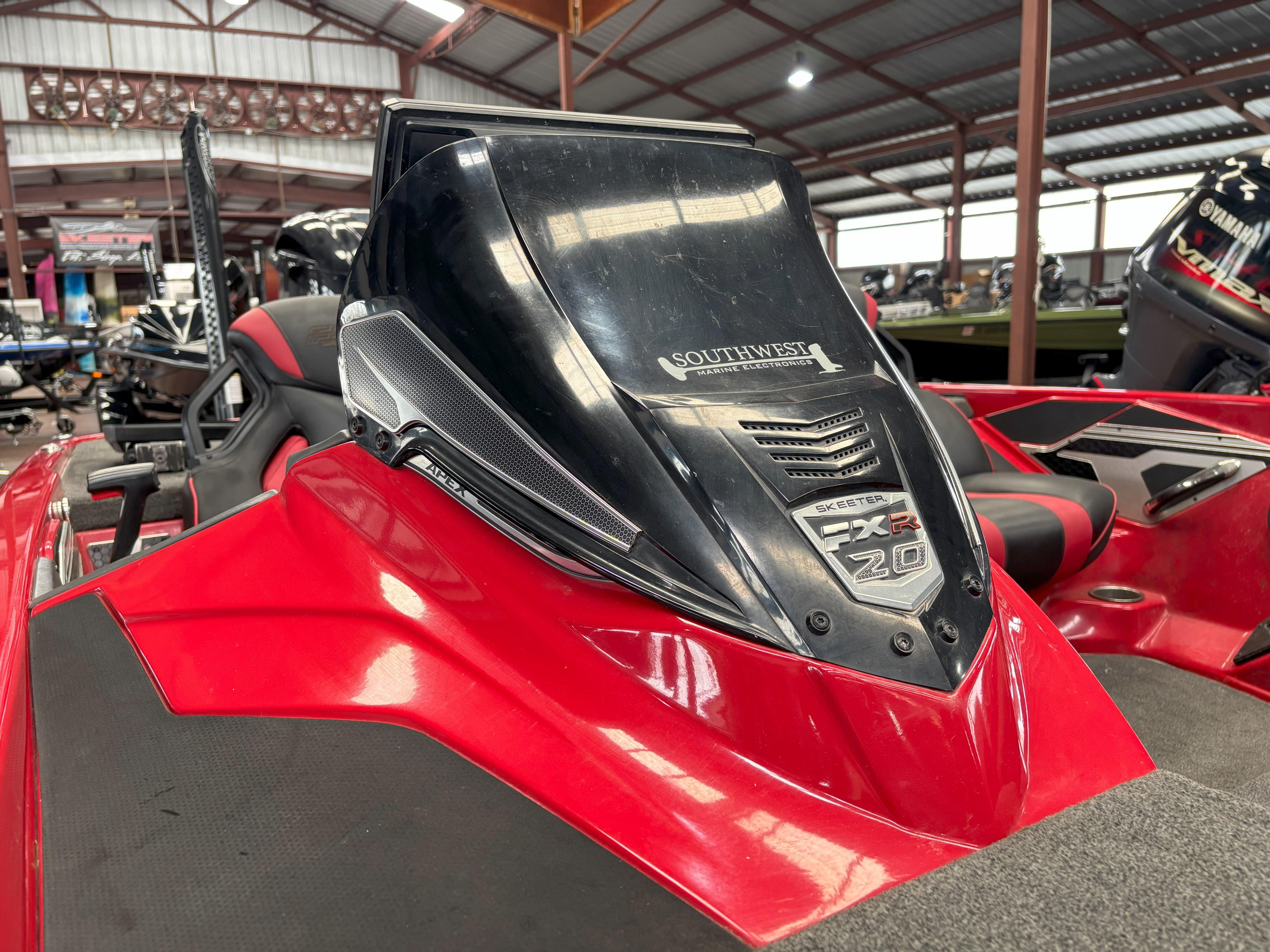 Slide: The Image of 2020 Skeeter FXR20 Apex boat in showroom, featuring sleek red and black design. - 3