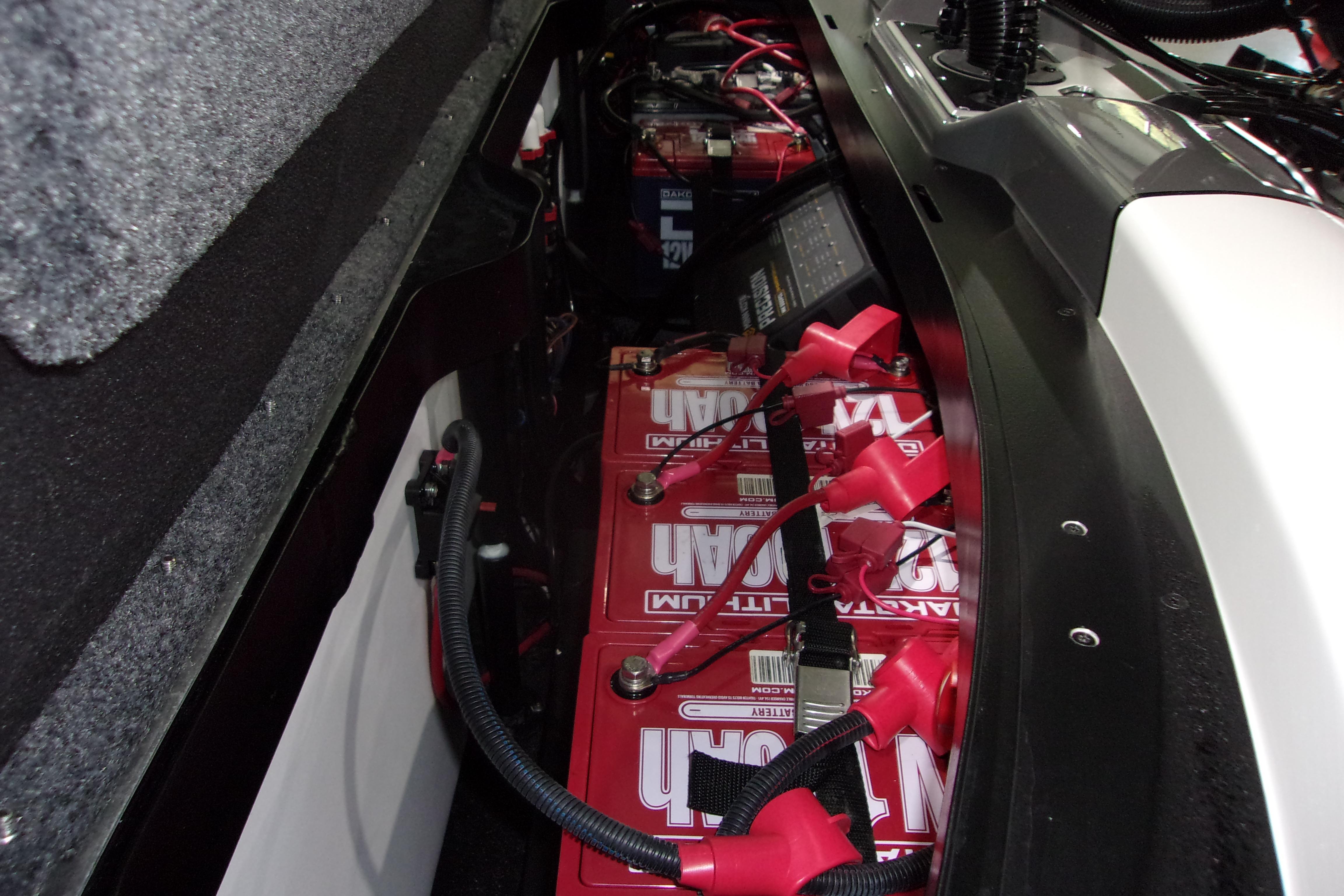 Slide: The Image of Battery compartment of 2025 Skeeter FXR21 Limited boat, featuring multiple red batteries. - 12