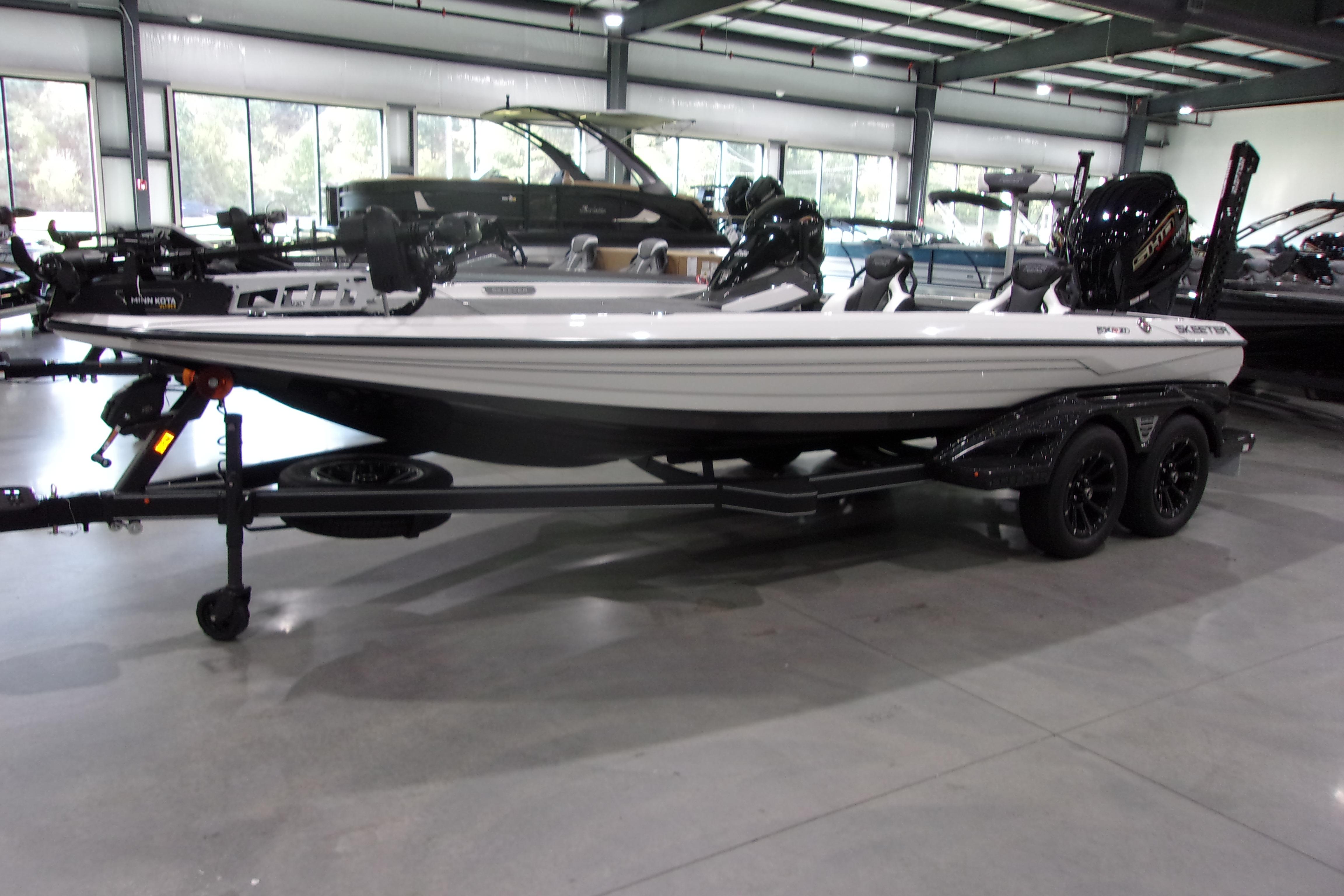 Slide: The Image of 2025 Skeeter FXR21 Limited boat in showroom, side view with trailer. - 2