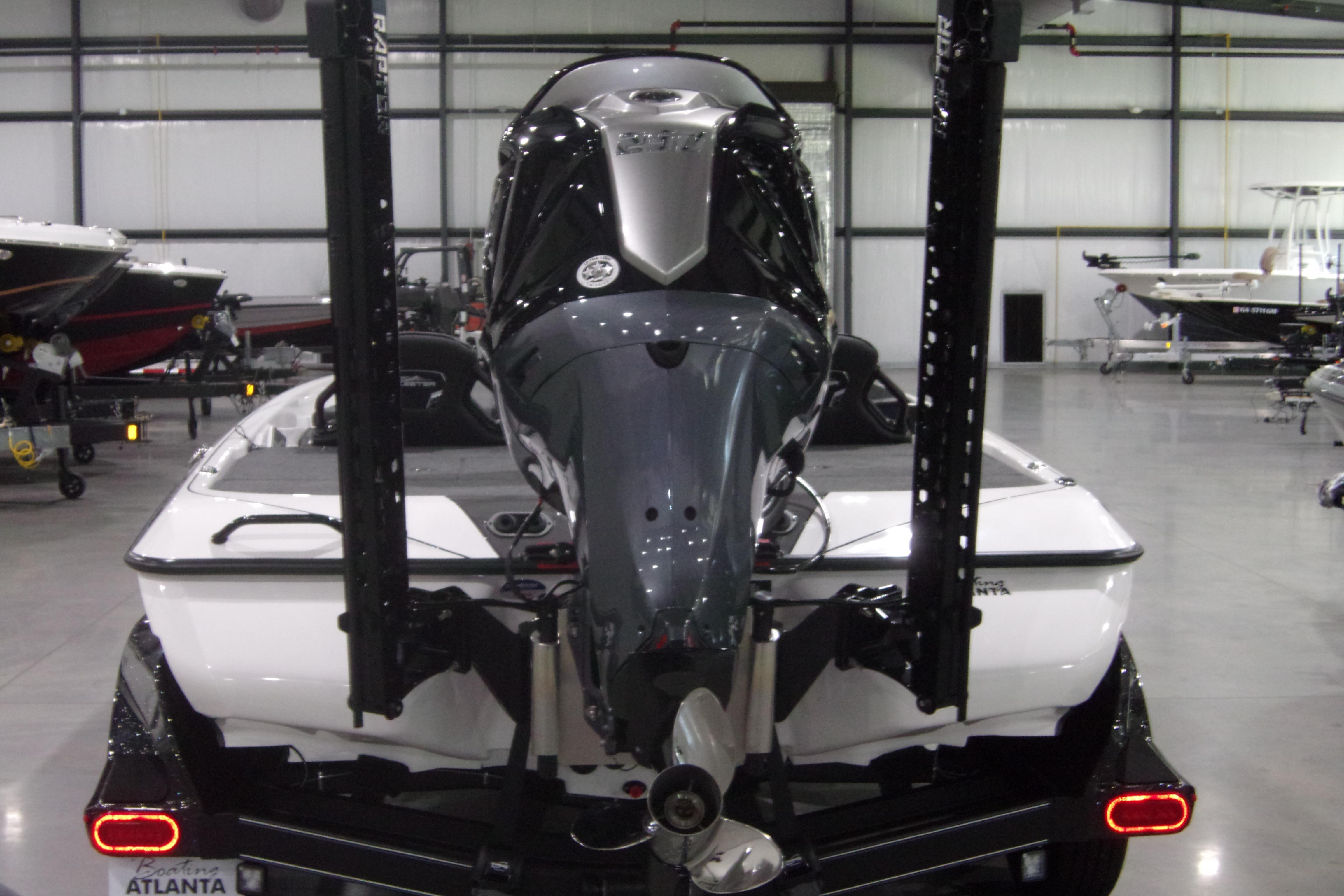 Slide: The Image of 2025 Skeeter FXR21 Limited boat in showroom, rear view with motor and trailer. - 8