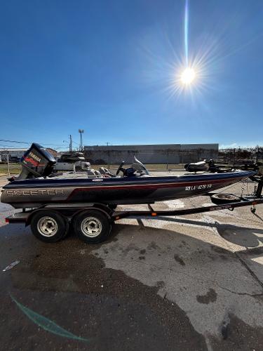 Slide: The Image of 2003 Skeeter SX 200 boat on a trailer under a bright sun. - 11