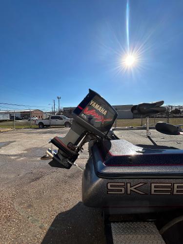 Slide: The Image of 2003 Skeeter SX 200 boat with Yamaha outboard motor under a bright sun. - 12